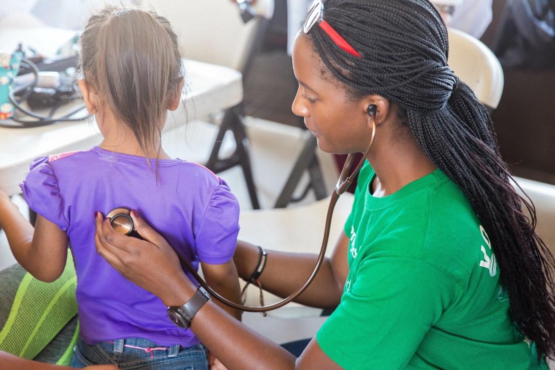 A local child has her heart beat checked by a Projects Abroad volunteer during a medical outreach in Mexico. A university student on a volunteer opportunity in Mexico checks a child's heart rate.